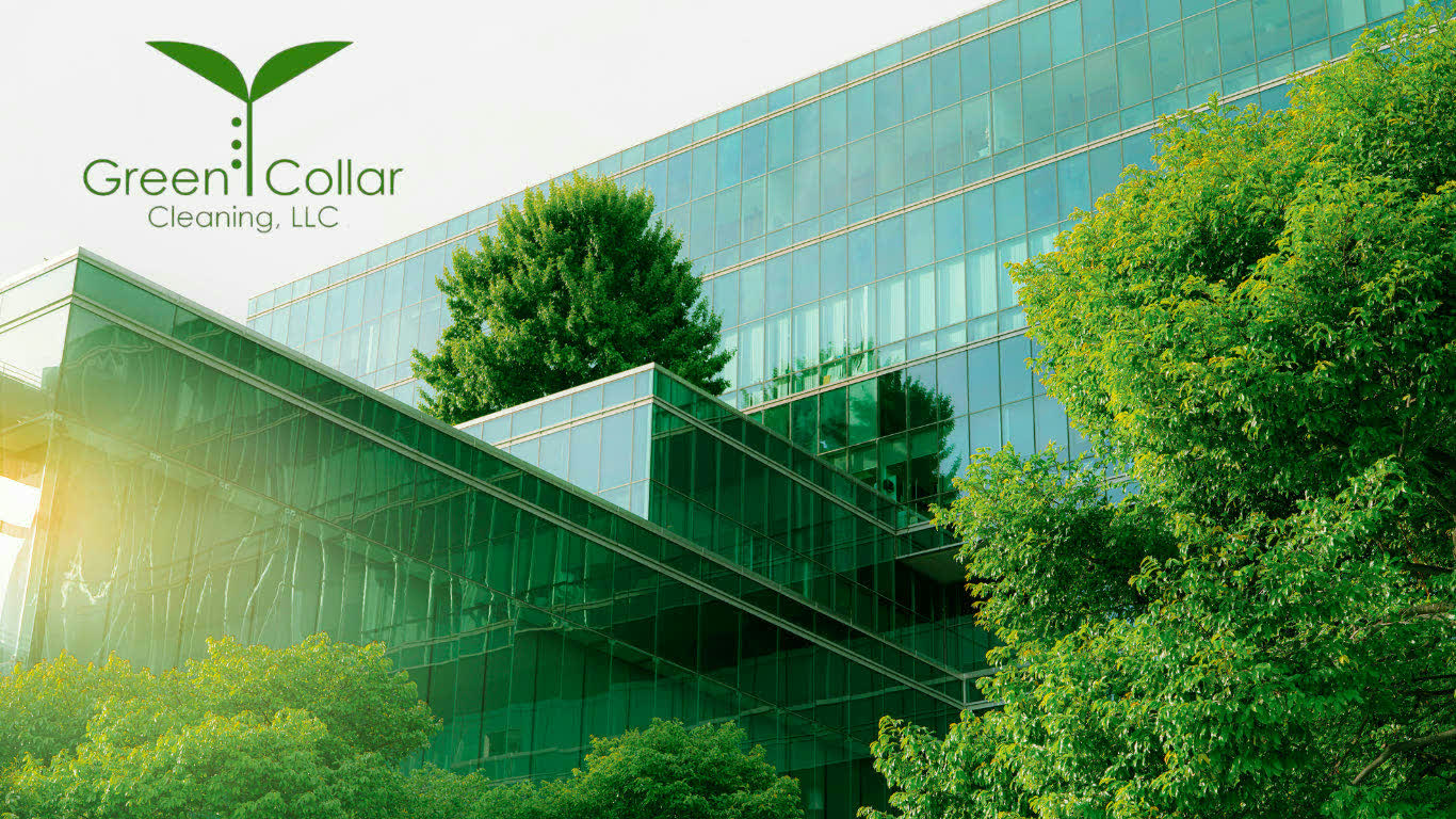 The Green Collar Cleaning logo above a glass office building surrounded by trees